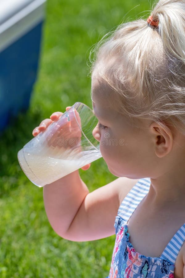 Plan rapproché de limonade potable de fille dehors en été photos stock Plan rapproché de limonade potable de fille dehors en été photos stock
