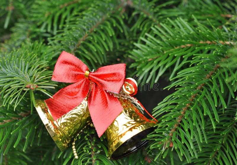 Plan rapproché de Noël-arbre avec les cloches d'or et l'arc rouge image libre de droits Plan rapproché de Noël-arbre avec les cloches d'or et l'arc rouge image libre de droits