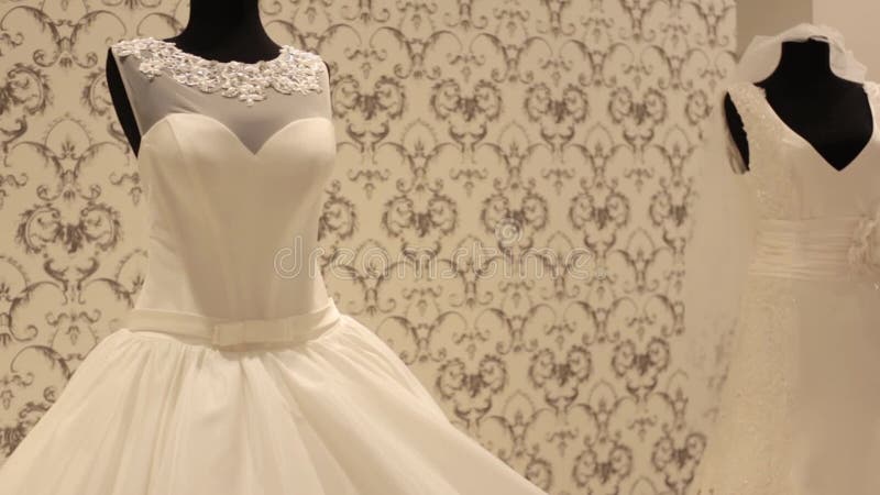 Plan rapproché de simulacre avec la robe de mariage, jeune belle femme choisissant une robe blanche dans une boutique de mariage