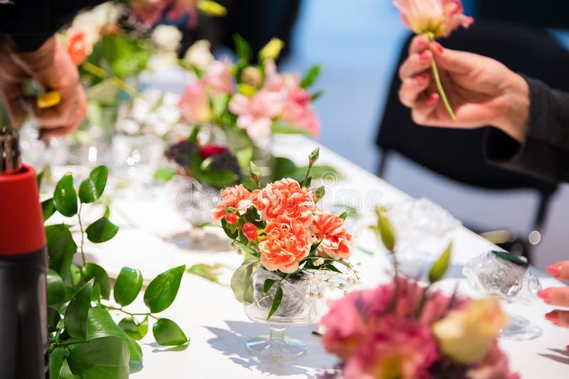 Plan rapproché des mains du fleuriste de jeune femme créant le bouquet des fleurs roses sur la table photos libres de droits Plan rapproché des mains du fleuriste de jeune femme créant le bouquet des fleurs roses sur la table photos libres de droits