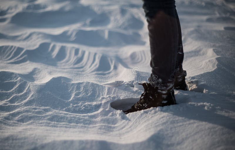 Plan rapproché des pieds du ` s de femme marchant sur le désert de neige au coucher du soleil Tir de ralenti de Stabiblized images stock Plan rapproché des pieds du ` s de femme marchant sur le désert de neige au coucher du soleil Tir de ralenti de Stabiblized images stock