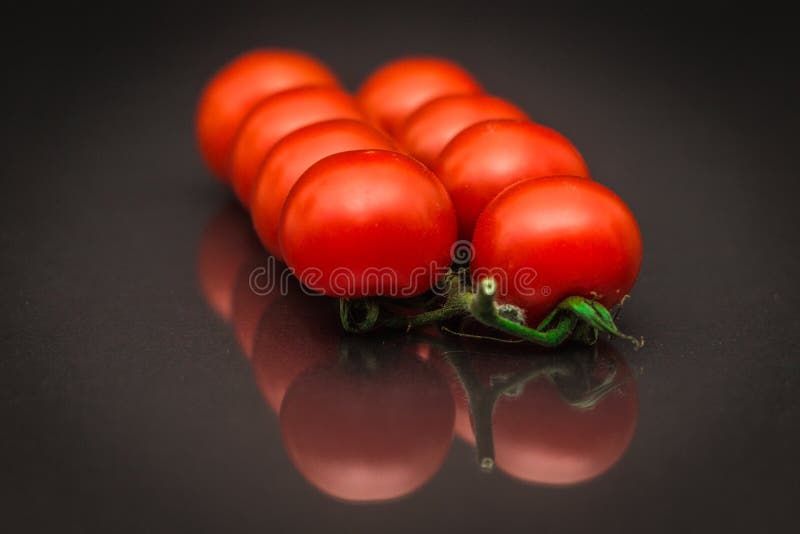 Plan rapproché des tomates rouges mûres de vigne se situant dans deux lignes image libre de droits Plan rapproché des tomates rouges mûres de vigne se situant dans deux lignes image libre de droits