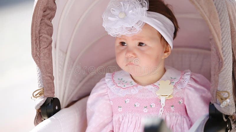 Plan rapproché du bébé mignon s'asseyant dans la voiture d'enfant banque de vidéos
