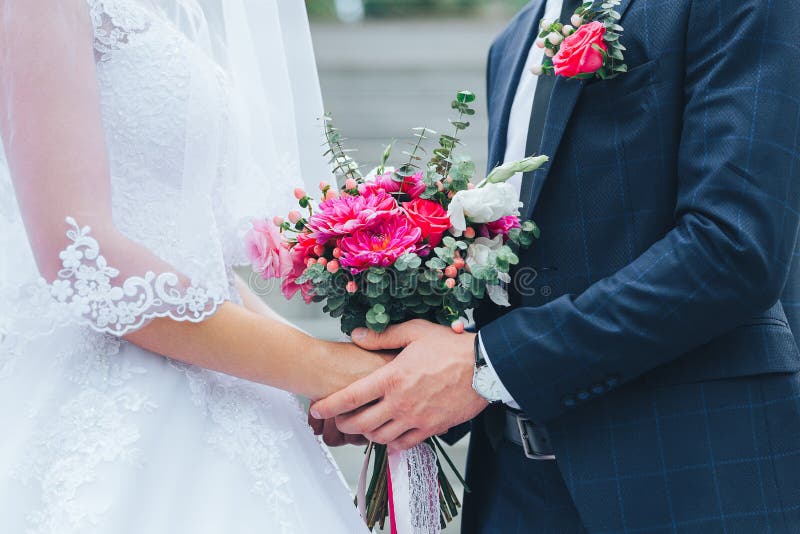 Plan rapproché du marié tenant la jeune mariée par les mains photographie stock Plan rapproché du marié tenant la jeune mariée par les mains photographie stock