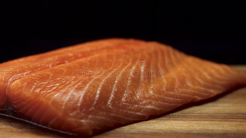 Plan rapproché du morceau juteux de saumons Tranche fraîche et rouge juteuse de viande saumonée se trouvant sur le conseil en boi