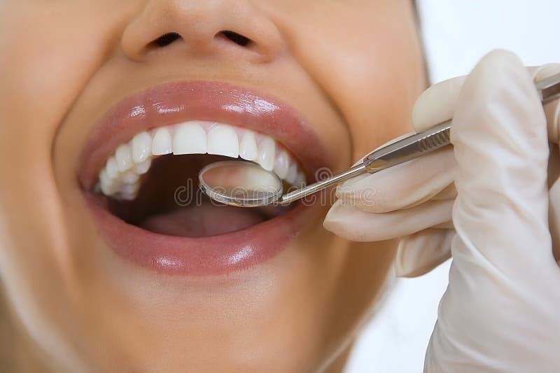 Plan rapproché du patient féminin faisant examiner ses dents par le dentiste image stock Plan rapproché du patient féminin faisant examiner ses dents par le dentiste image stock