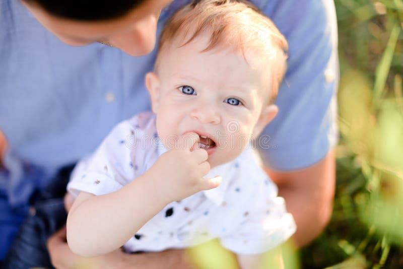 Plan rapproché peu de bébé sur le fond bleu de T-shirt de père photos libres de droits Plan rapproché peu de bébé sur le fond bleu de T-shirt de père photos libres de droits