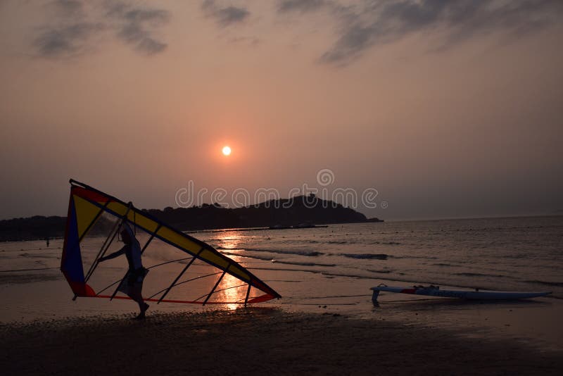 Planche à voile d'homme au coucher du soleil photo libre de droits Planche à voile d'homme au coucher du soleil photo libre de droits