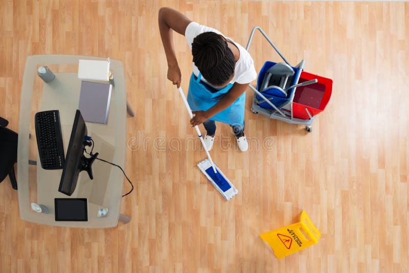 High Angle View Of African Woman Cleaning Hardwood Floor With Mop. High Angle View Of African Woman Cleaning Hardwood Floor With Mop
