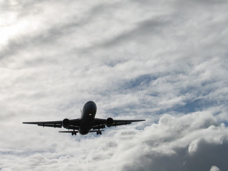 Atterraggio aereo silhouette in un giorno nuvoloso.