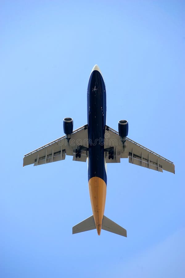 Underside of flying plane against blue sky. Underside of flying plane against blue sky.