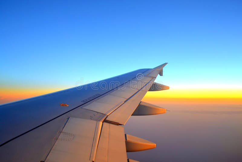 Plane wing on sunset sky stock image