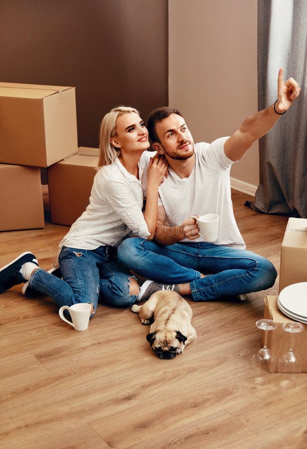 Planeamiento joven de los pares que se mueve en el nuevo apartamento fotografía de archivo libre de regalías Planeamiento joven de los pares que se mueve en el nuevo apartamento fotografía de archivo libre de regalías