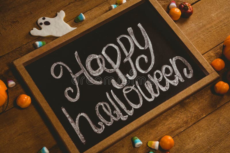 Planen Sie mit glücklichem Halloween-Text durch Süßigkeiten auf Holztisch stockfotografie Planen Sie mit glücklichem Halloween-Text durch Süßigkeiten auf Holztisch stockfotografie
