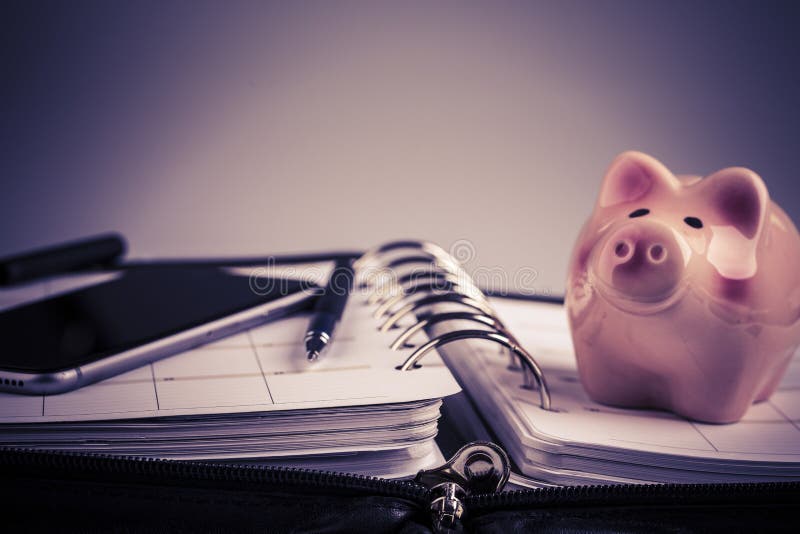 Planning concept - calendar, cellphone, pen, pig moneybox