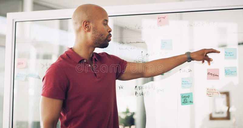 Planning, glass wall and man with sticky note, office and ideas for agenda, brainstorming and business. Presentation stock photography