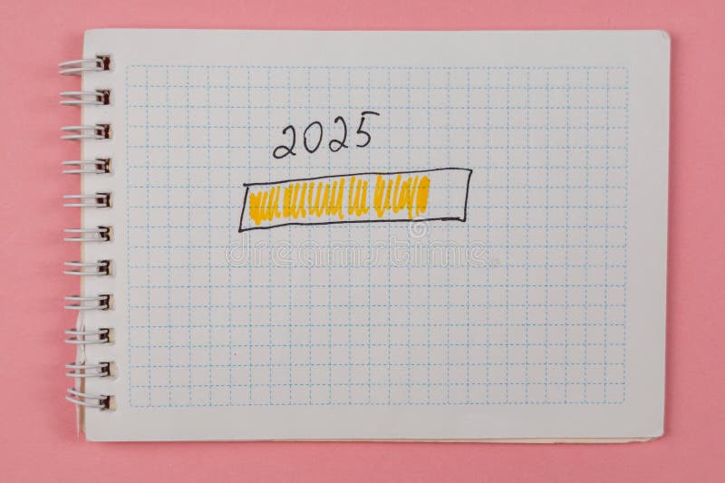 Planning for 2025 with notes in a spiral notebook on a pink background royalty free stock photos