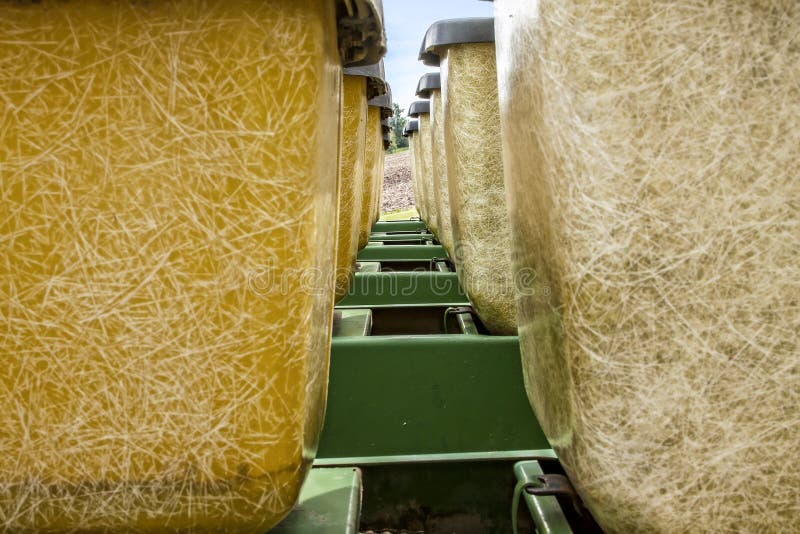 Looking at a field between the seed hoppers on seed planter that is pulled behind a tractor. Looking at a field between the seed hoppers on seed planter that is pulled behind a tractor.