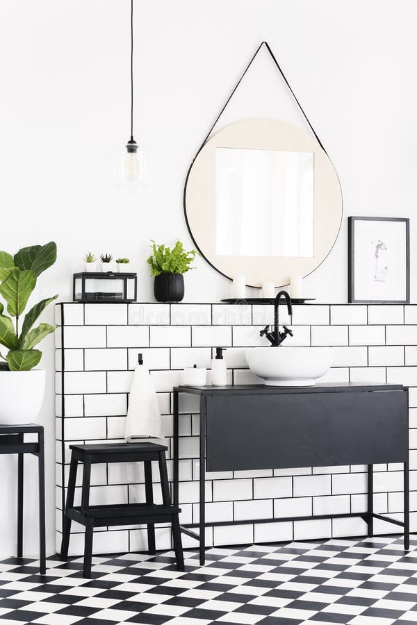 Plants and mirror in black and white bathroom interior with checkered floor and stool. Real photo royalty free stock images Plants and mirror in black and white bathroom interior with checkered floor and stool. Real photo royalty free stock images