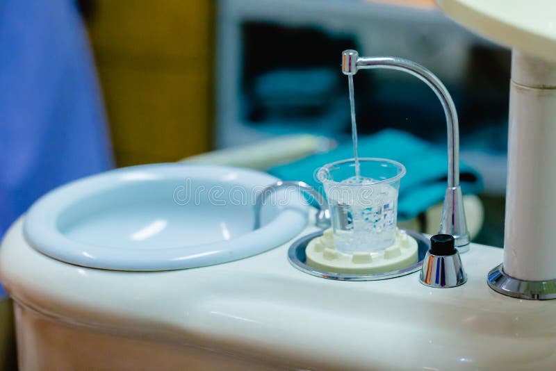 Plast- exponeringsglas med vatten för gemensam operation för tandläkare av cleanin royaltyfria bilder Plast- exponeringsglas med vatten för gemensam operation för tandläkare av cleanin royaltyfria bilder
