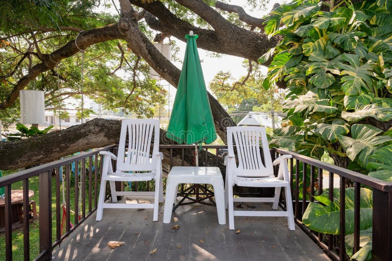 Plastic Armchair with Table and Parasol on Patio in Garden Stock Image