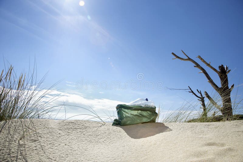 Boy Carrying Plastic Bag Filled with Garbage on Beach Stock Photo