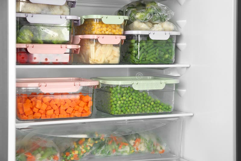 Plastic Bags and Containers with Frozen Vegetables in Refrigerator