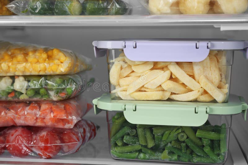 Plastic Bags and Containers with Frozen Vegetables in Refrigerator