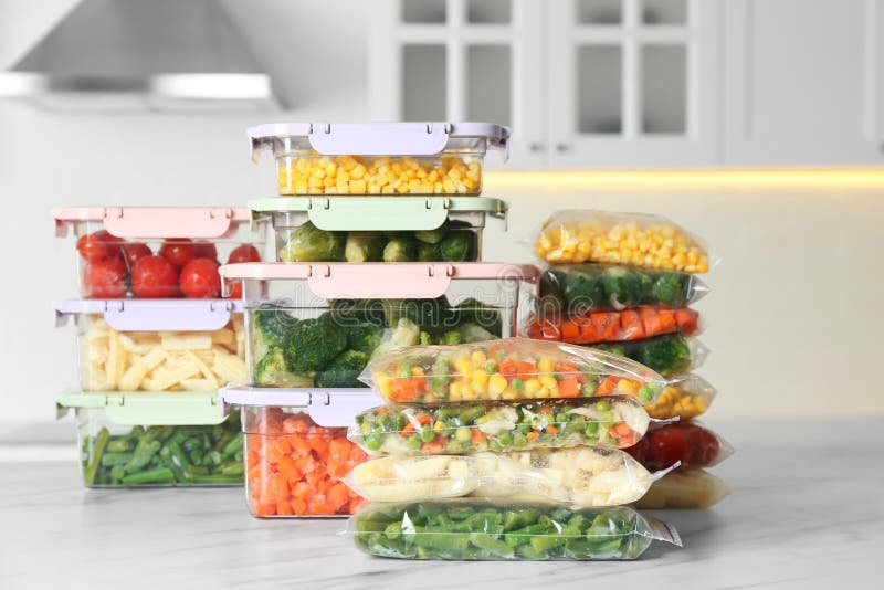 Plastic Bags and Containers with Frozen Vegetables on White Marble