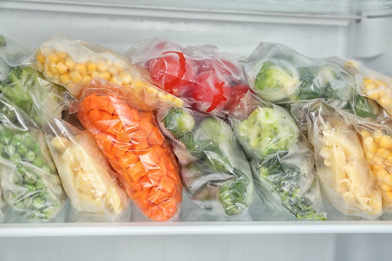 Plastic Bags and Containers with Frozen Vegetables in Refrigerator