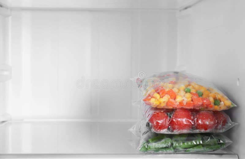 Plastic Bags with Frozen Vegetables in Refrigerator. Space for Text