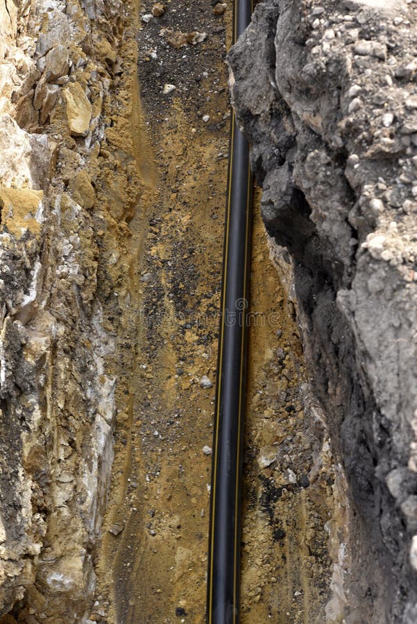 A Plastic Black Gas Pipe at the Bottom of the Trench. a Dug Trench for Laying a Gas Pipe Stock