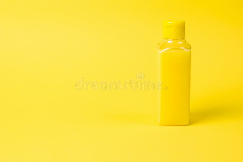 Plastic Bottle with Yellow Liquid on a Yellow Background Stock Image