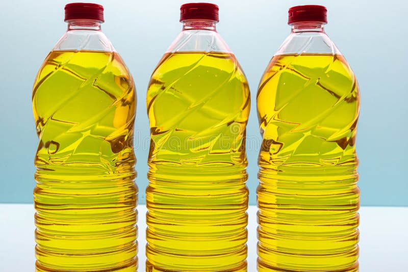 Plastic bottles with edible soy oil on blue background