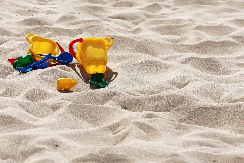 Plastic colored toys in the sand royalty free stock photo