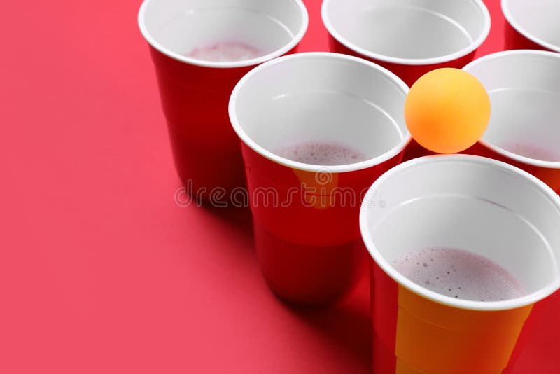 Red plastic cups and ball for game of beer pong Stock Photo by