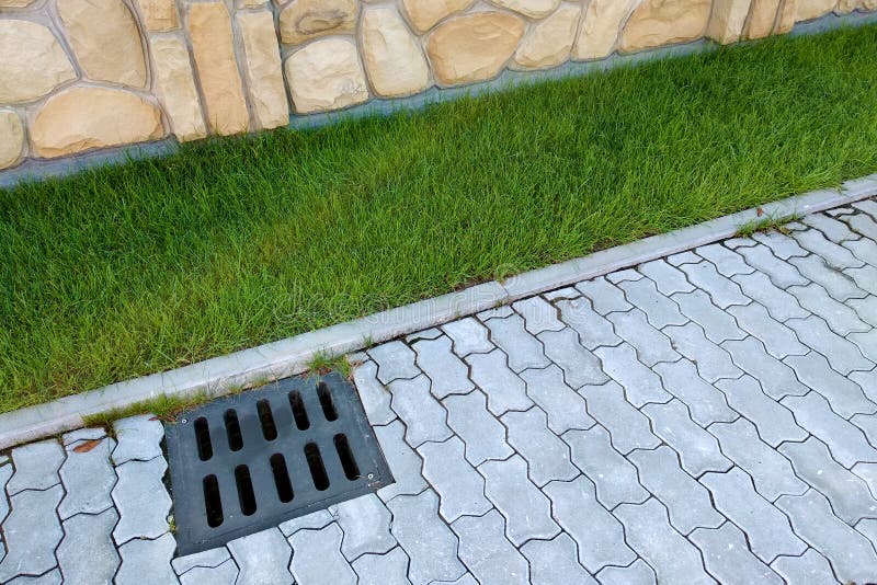 Plastic Drain Gutter, Green Grass Lawn and Stone Pavement Sidewalk