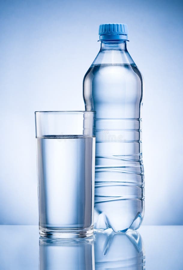 Plastic fles en glas drinkwater op blauwe rug
