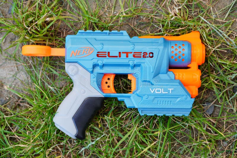 Plastic Nerf Toy with Orange and Blue Handles, Resting on a Patch of