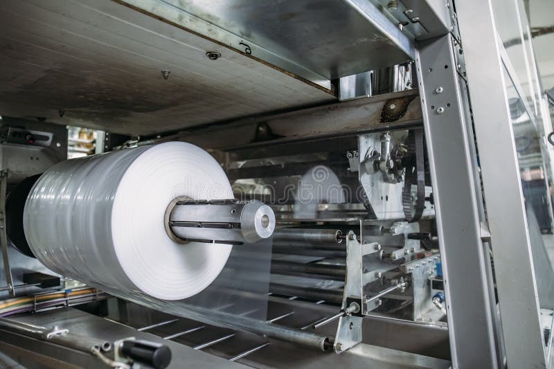 Plastic roll in industrial food packaging machine equipment tool at factory workshop royalty free stock image Plastic roll in industrial food packaging machine equipment tool at factory workshop royalty free stock image