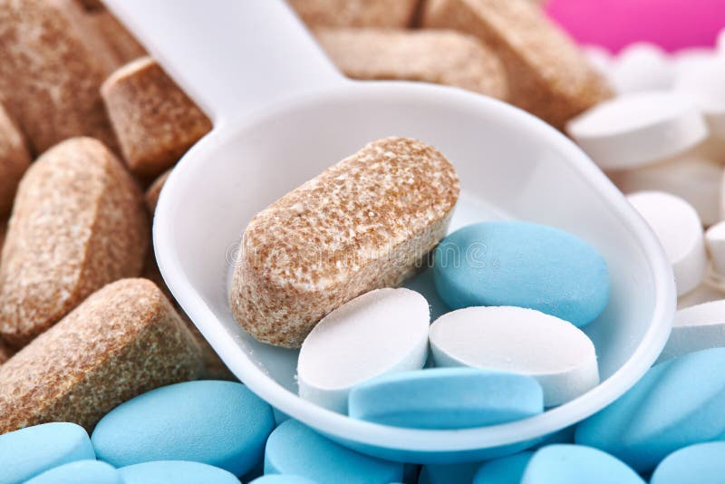 Plastic spoon and blue, brown and white pills royalty free stock photo Plastic spoon and blue, brown and white pills royalty free stock photo