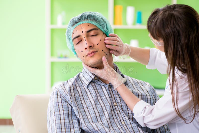 The Plastic Surgeon Preparing for Operation on Man Face Stock Photo
