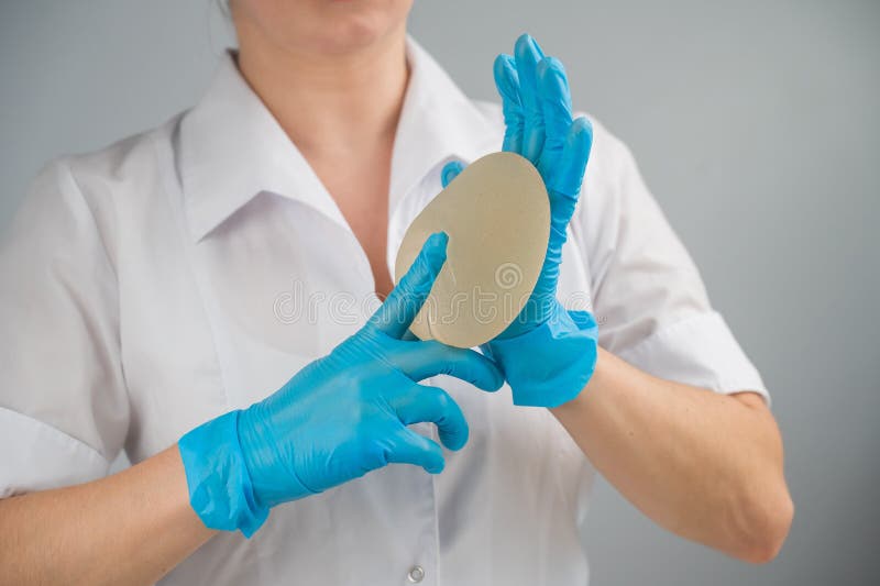 A Plastic Surgeon Shows a Breast Silicone Implant. Stock Photo Image of choose, enhancement