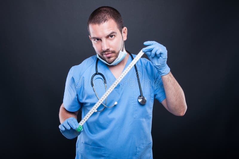 Plastic surgeon wearing scrubs showing measuring tape royalty free stock photos Plastic surgeon wearing scrubs showing measuring tape royalty free stock photos