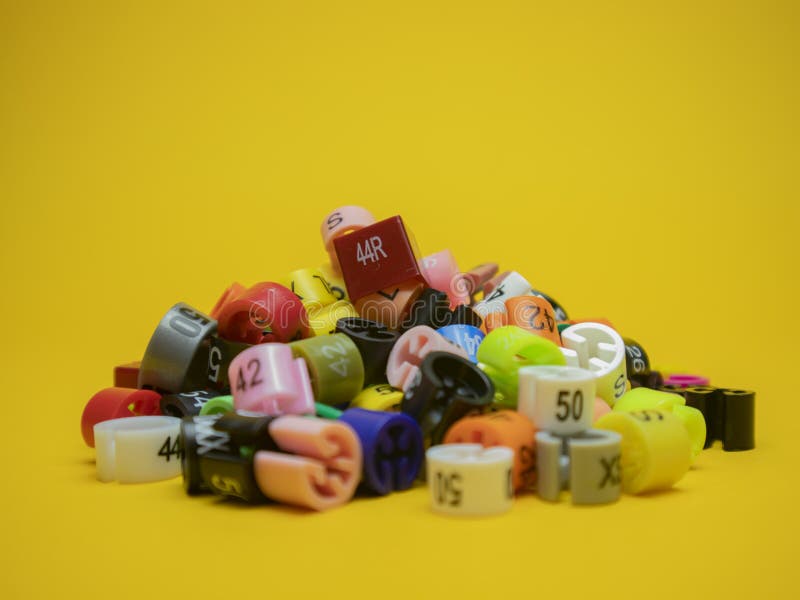Plastic Tags of Clothing Sizes for the Store. Isolated on a Yellow
