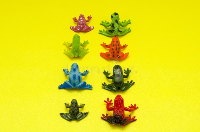 Plastic Toy Frogs Against Yellow Background Stock Image - Image of