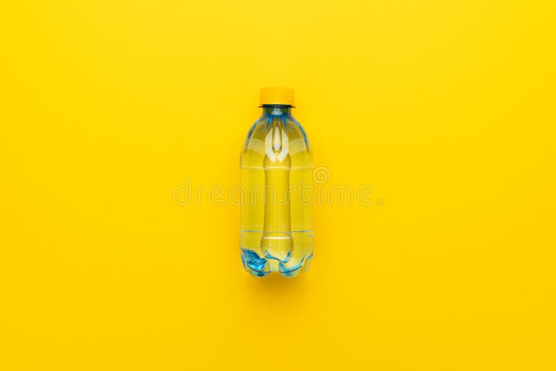 Plastic Water Bottle with Yellow Cap on Yellow Background Stock Photo