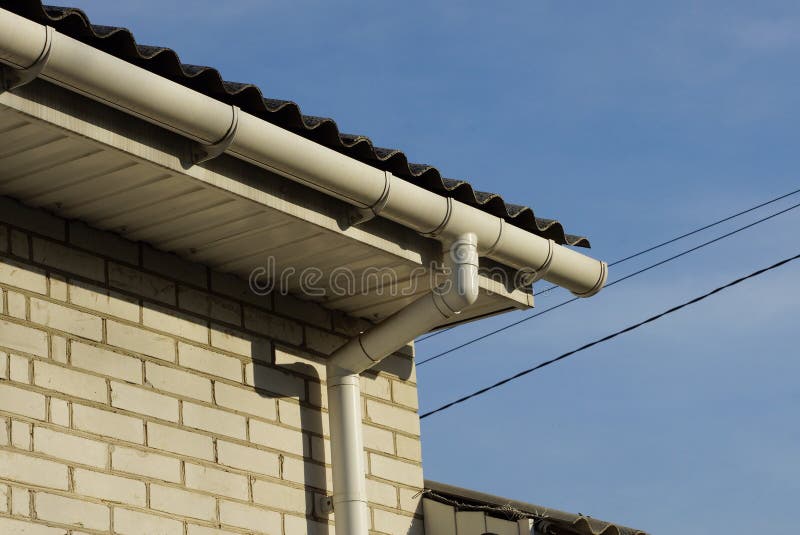 Plastic white gutter pipes on the wall of the house royalty free stock photo