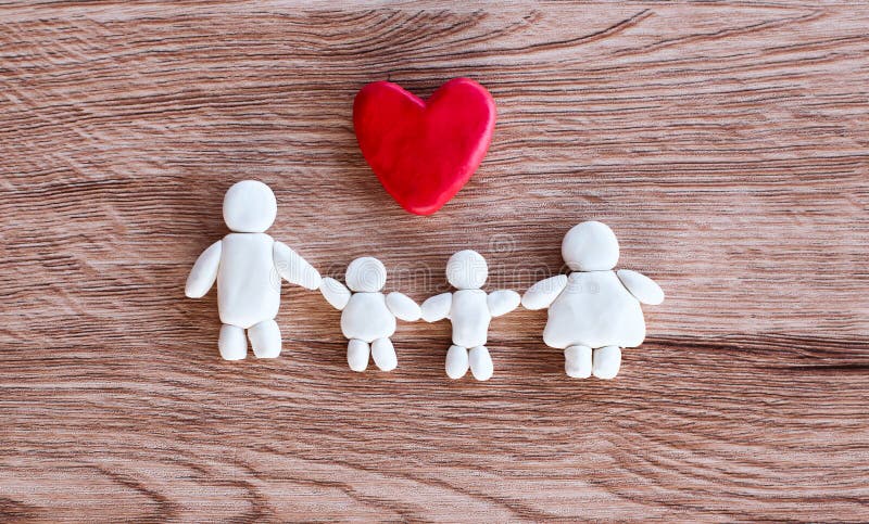 Plasticine clay happy family with heart on wooden background Happy family and love concept