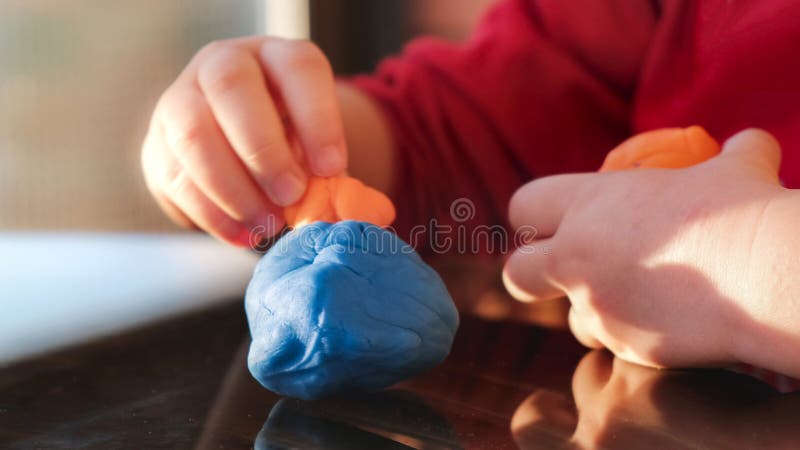 plasticine hands of the baby play with modelling clay playdought